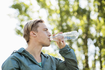 Fit man drinking water outdoors