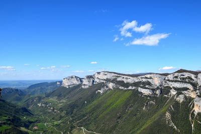 Scenic view of mountains against blue sky