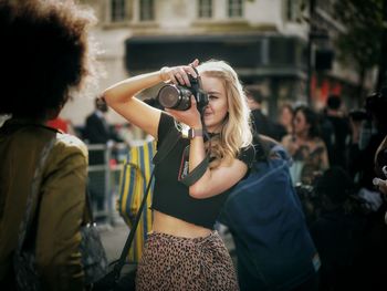 Young woman photographing with camera