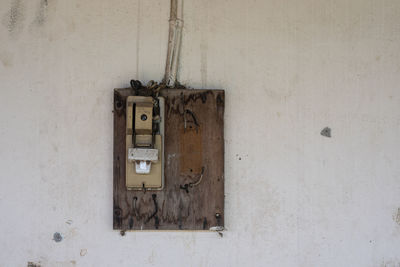 Close-up of old telephone booth on wall