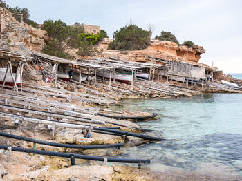 Scenic view of rocks by sea against sky