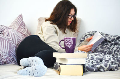 Woman sitting on bed at home