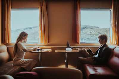 People sitting on table by window