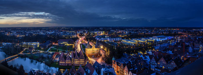 Aerial view of illuminated cityscape against sky at night