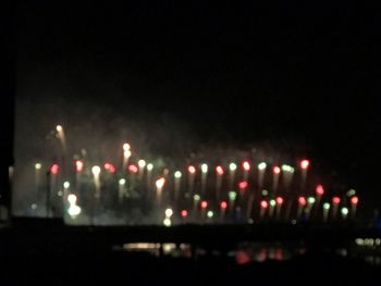 Defocused image of illuminated lights in city at night