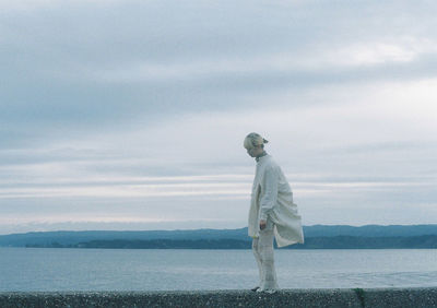 Man standing by sea against sky