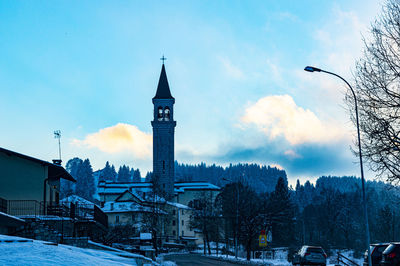 Buildings in snow covered city against sky