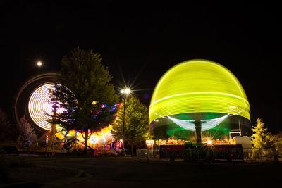 Low angle view of illuminated ferris wheel against sky at night