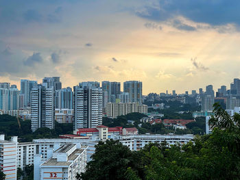 Buildings in city against sky during sunset