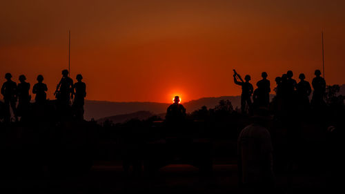 Silhouette people against sky during sunset