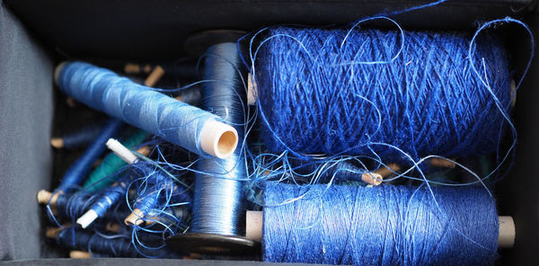 Close-up of blue spools in container