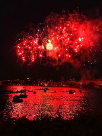 Firework display over river at night