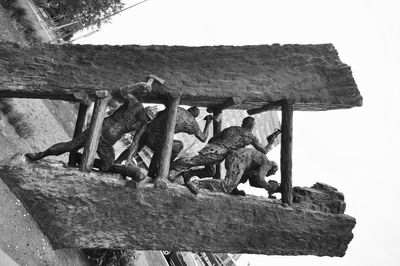 Low angle view of wooden post against sky