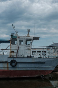 Boats moored at harbor against sky