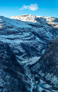 Scenic view of snowcapped mountains against blue sky