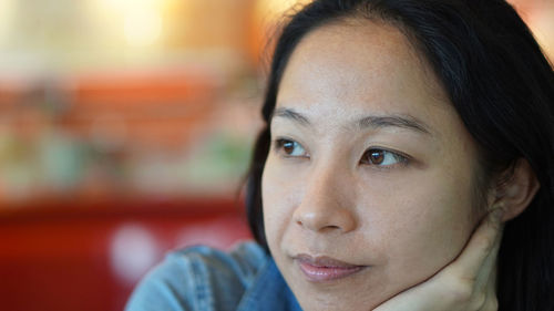 Close-up portrait of beautiful young woman looking away