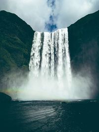 Scenic view of waterfall against sky