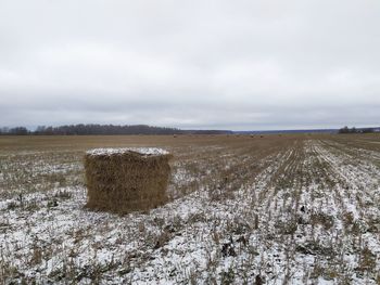 Hay bales on field against sky