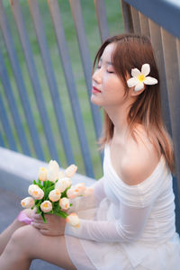 Portrait of young woman holding flowers