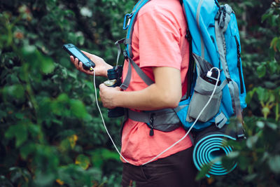 Midsection of male hiker using mobile phone