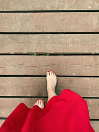 Low section of person relaxing on wooden floor