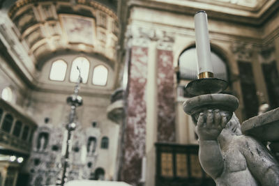 Low angle view of sculpture with candle in church