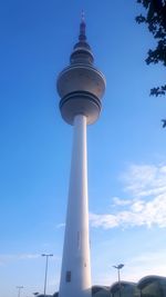 Low angle view of communications tower against blue sky