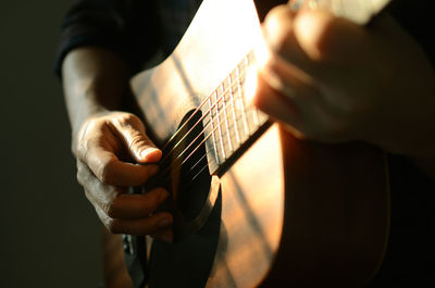 Midsection of man playing guitar