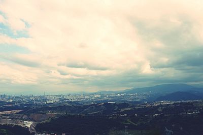 View of cityscape against cloudy sky