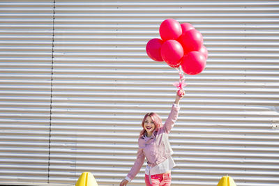 Rear view of woman holding red balloons