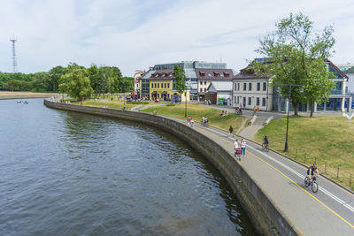 Bridge over river by buildings in city against sky