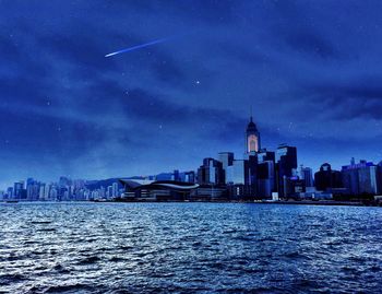 Illuminated cityscape against sky at dusk