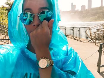 Portrait of woman wearing sunglasses and raincoat