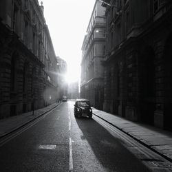 Cars on road amidst buildings in city