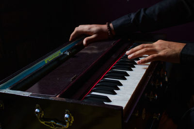 Midsection of man playing piano