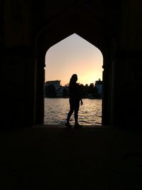 Silhouette of people standing in front of sea