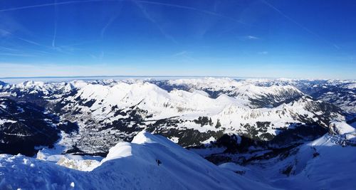 Scenic view of snowcapped mountains against blue sky