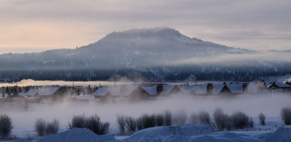 Panoramic view of snow covered mountains against sky