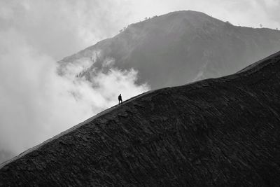 Silhouette man climbing on mountain