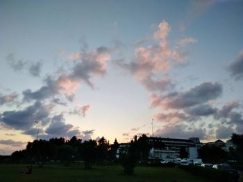 Silhouette trees and buildings against sky during sunset