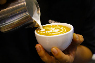 Close-up of hand holding coffee cup