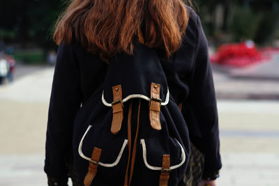 Back view of young brunette woman walking. woman with rucksack in the city. back to school, college