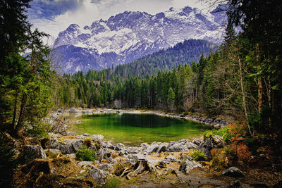 Scenic view of lake by mountains against sky