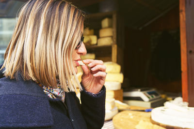 Woman eating cheese at store