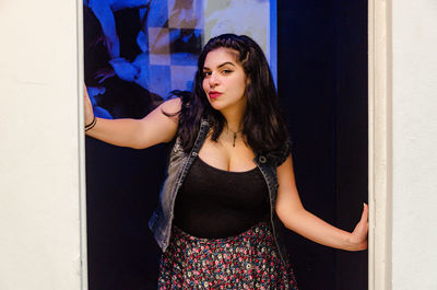 Beautiful young woman standing against door