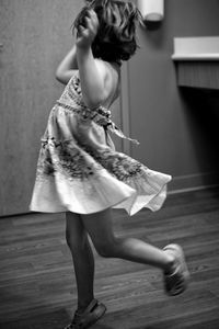 Playful girl jumping on floor at home