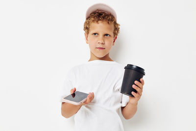 Portrait of cute girl using mobile phone against white background