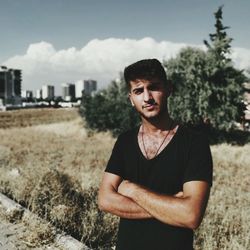 Portrait of young man standing against plants