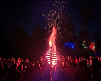 Crowd at music concert against sky at night