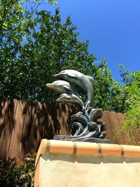 Low angle view of statue against trees in park